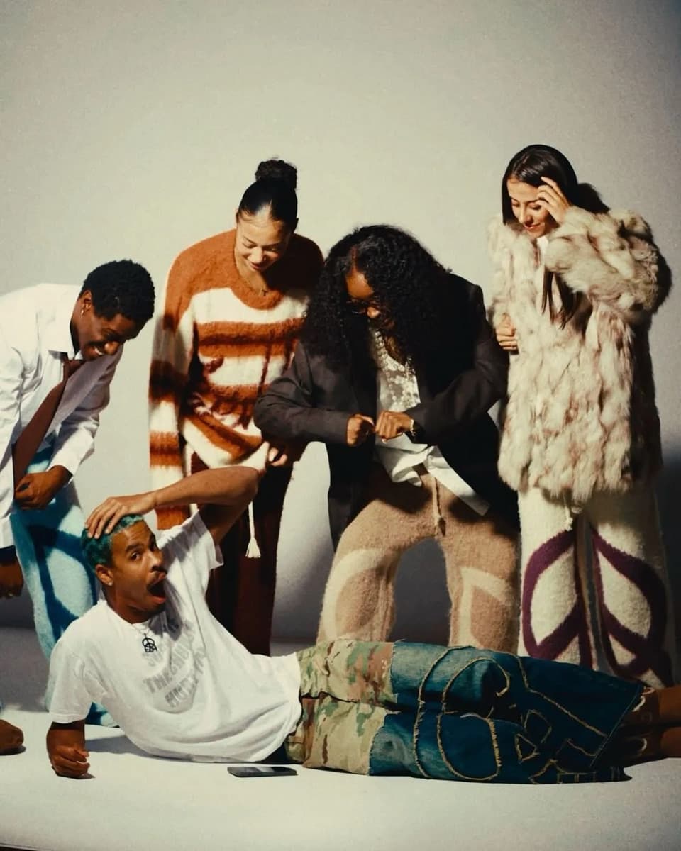 Friends in a studio wearing fuzzy knit trousers, a striped sweater and a fur coat